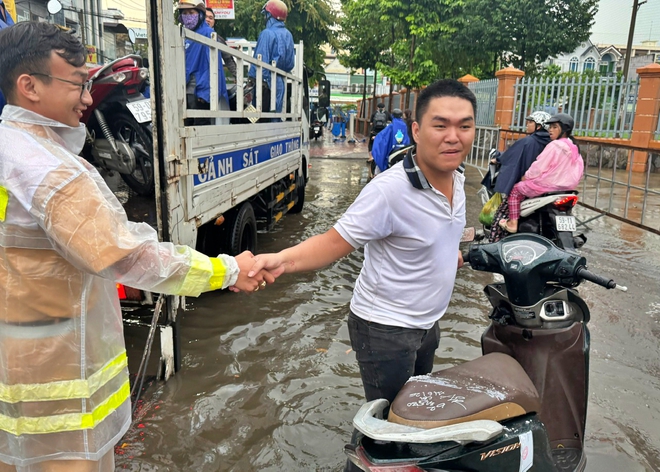 Cảnh s&aacute;t giao th&ocirc;ng Th&agrave;nh phố Hồ Ch&iacute; Minh hỗ trợ người d&acirc;n di chuyển qua đoạn đường ngập s&acirc;u - Ảnh 3.