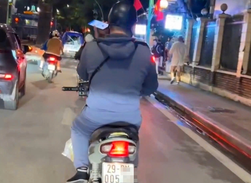 1 thanh niên bị phạt tiền và trừ 4 điểm giấy phép lái xe vì sử dụng điện thoại khi điều khiển mô tô  - Ảnh 1.