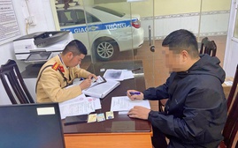 Một thanh niên sử dụng điện thoại khi điều khiển mô tô bị phạt tiền và trừ 4 điểm giấy phép lái xe