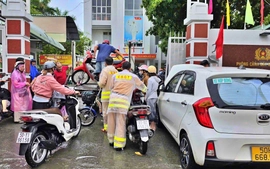 Cảnh sát giao thông Thành phố Hồ Chí Minh hỗ trợ người dân di chuyển qua đoạn đường ngập sâu