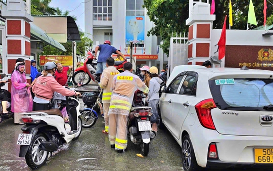 Cảnh sát giao thông Thành phố Hồ Chí Minh hỗ trợ người dân di chuyển qua đoạn đường ngập sâu